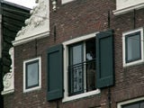 на балконе мансарды чернокожий мужчина... / Нидерланды