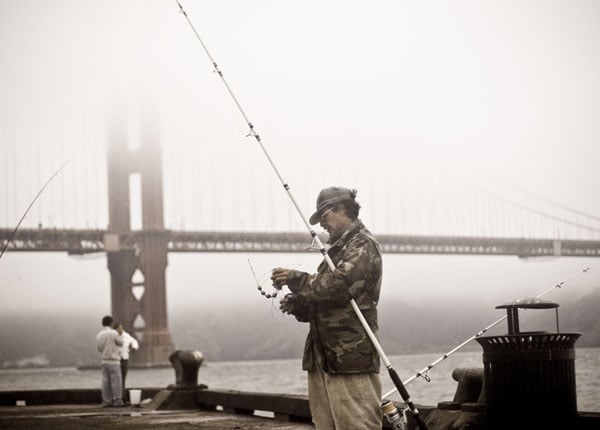 Рыбак на пирсе перед мостом в Сан-Франциско / Фото из США