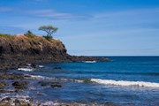 Каменистые рифы увеличивают волны.  // Pierre-Yves Babelon, Shutterstock.com