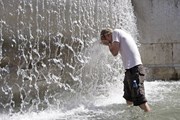В жару туристов так и тянет к фонтанам. // Barcroft Media
